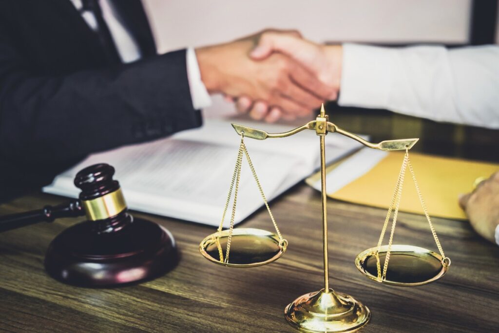 Un avocat serre la main de son client après avoir négocié une cession de commerce