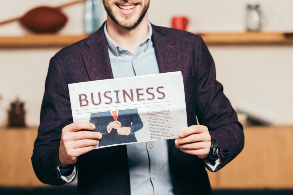 Un homme montrant un journal avec des idées de business pour un jeune entrepreneur