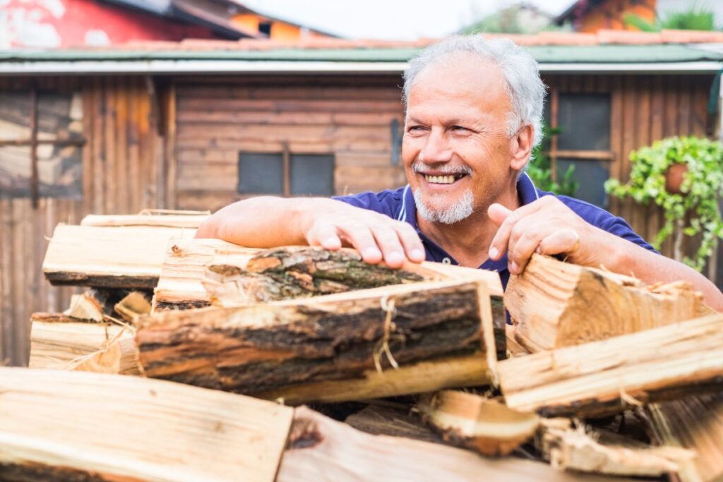 Un homme souriant qui vend des bois de chauffage