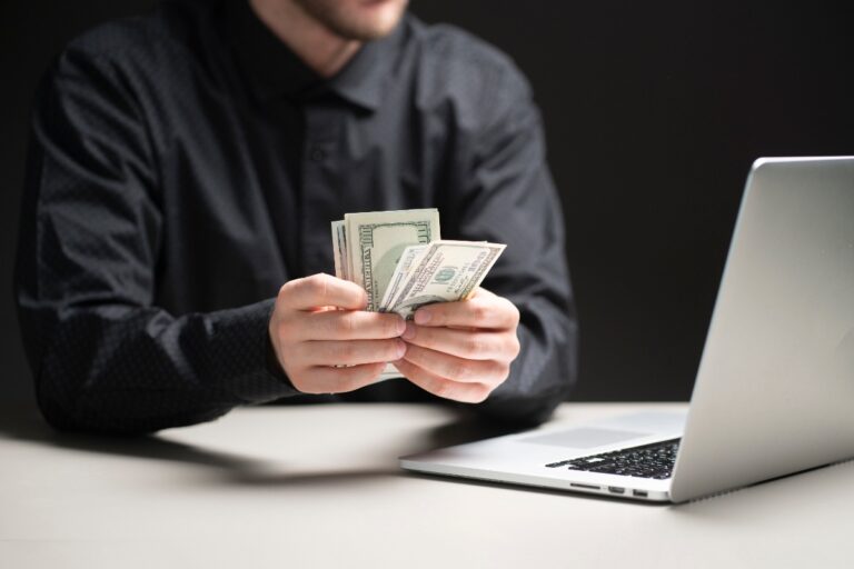 Un community manager comptant son salaire devant un ordinateur