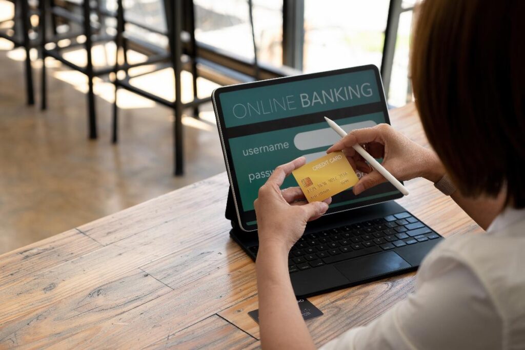 Une personne assise dans son bureau en regardant sa carte bancaire