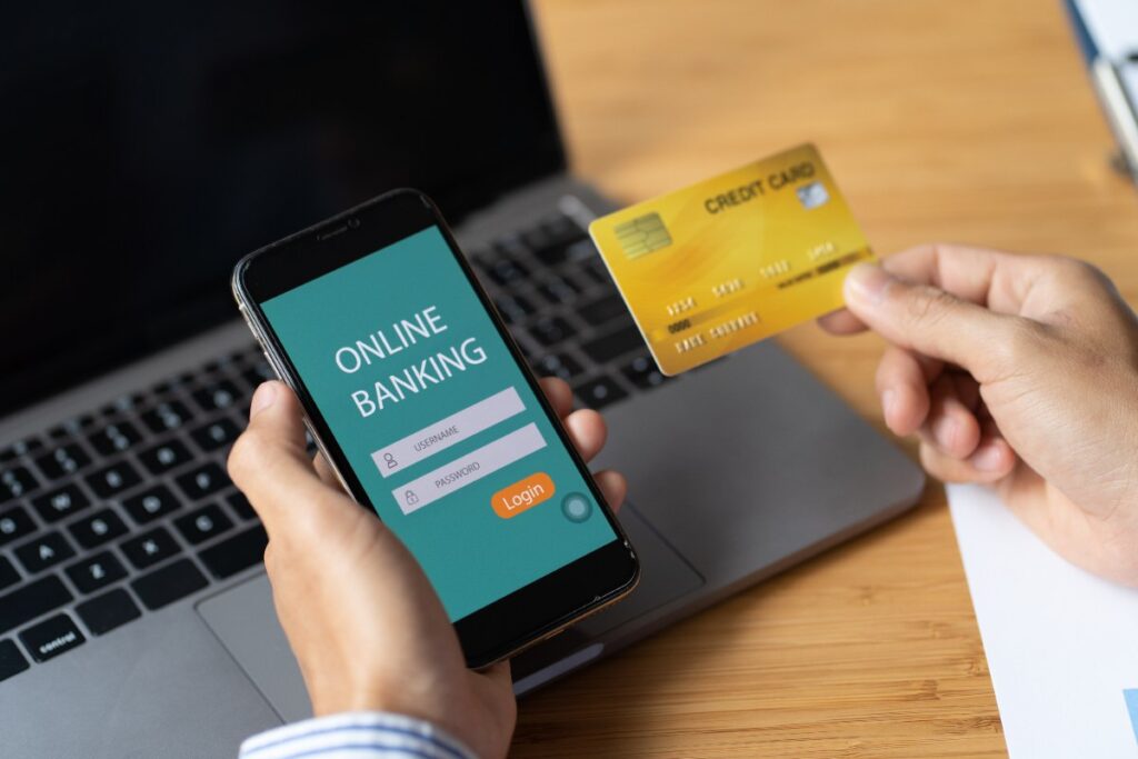 Une personne qui regarde une carte bancaire et son téléphone