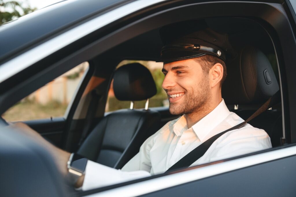 Un chauffeur souriant dans sa voiture