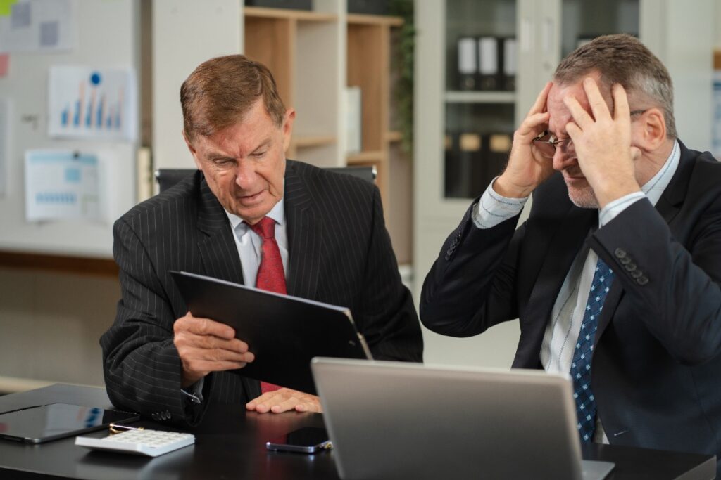 Deux hommes en costumes regardant des documents