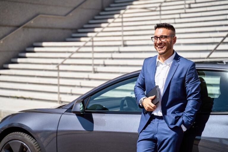 Un homme d'affaire penché sur une voiture