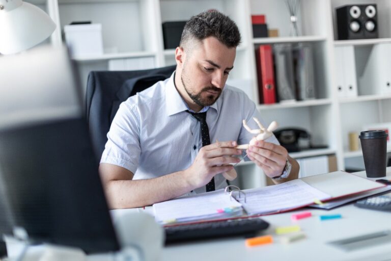 Un homme assis sur une table de bureau