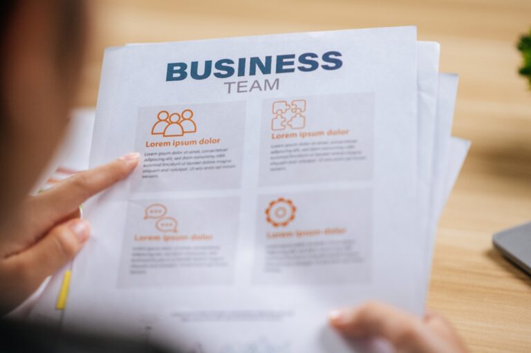 Une personne analysant un plan de business sur des papiers