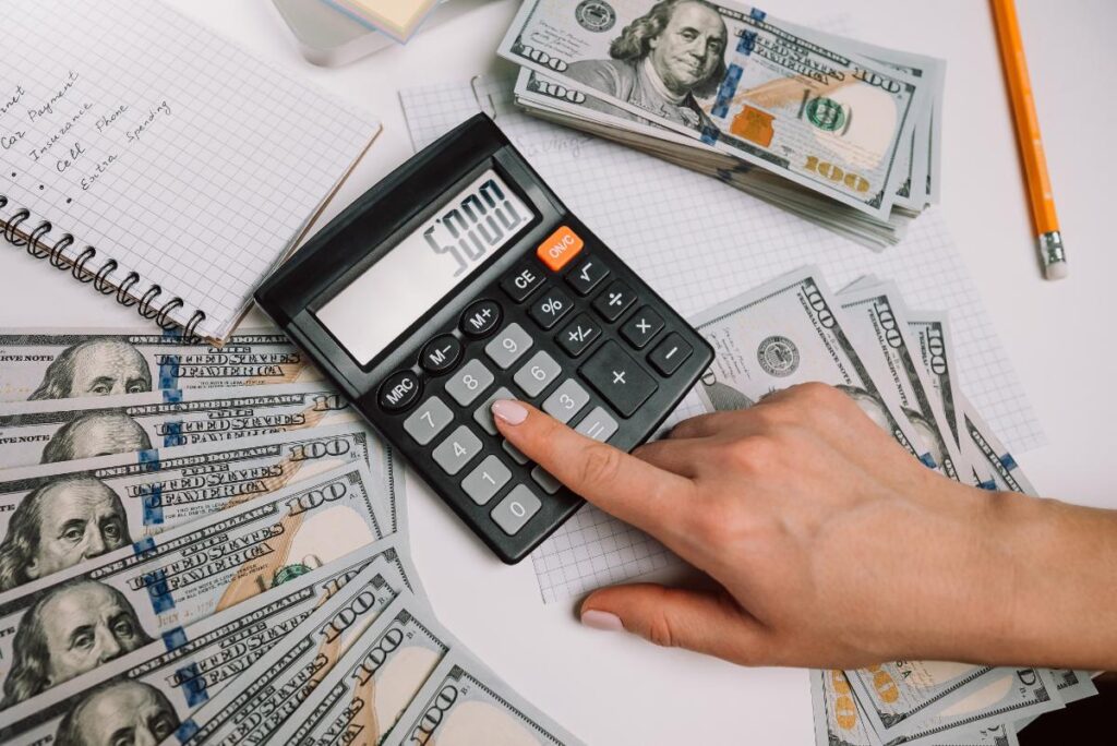 Une personne faisant un calcul de son salaire brut net avec une calculatrice