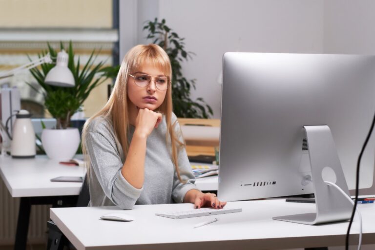 Une femme assise dans son bureau devant son ordinateur