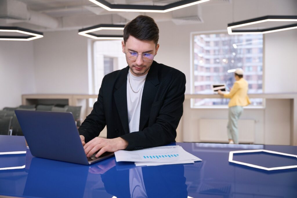 Un homme assis dans un bureau et travaille avec son ordinateur portable