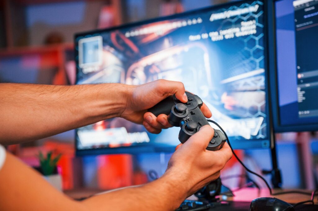 Mains tenant une manette de jeux