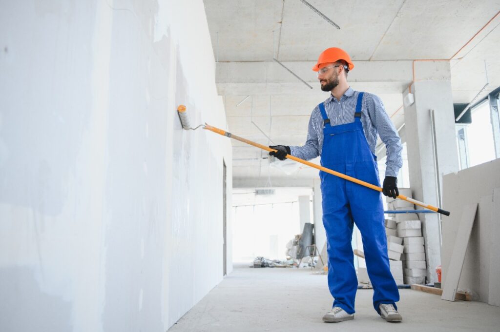 Un ouvrier de bâtiment peignant le mur