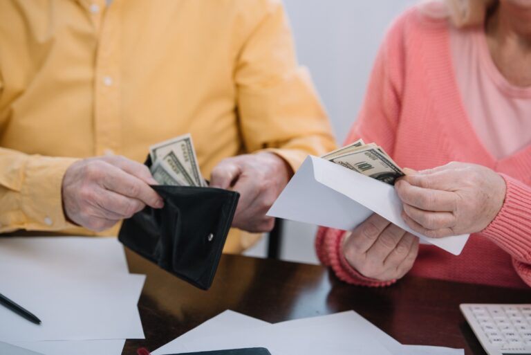 Des personnes âgées sortant de l'argent dans une enveloppe