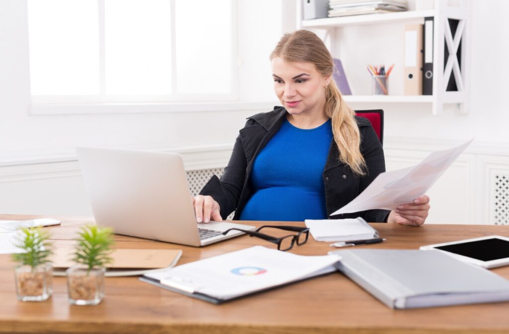 Une femme enceinte travaillant sur un ordinateur