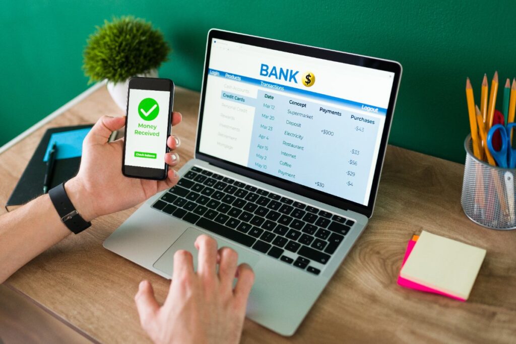 Une personne tenant un téléphone et effectuant une transaction bancaire 