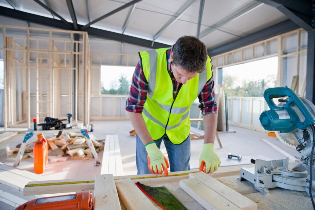 Un charpentier mesurant une planche en bois