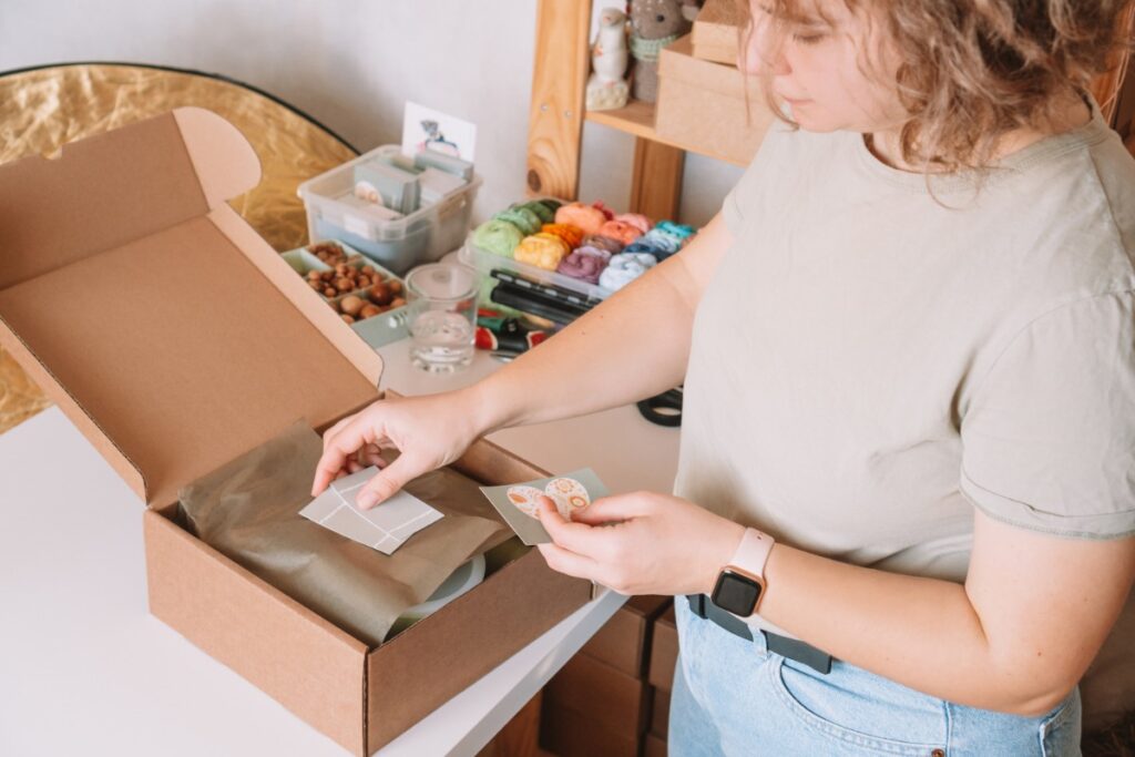 Une femme emballant des commandes avec des petits papiers