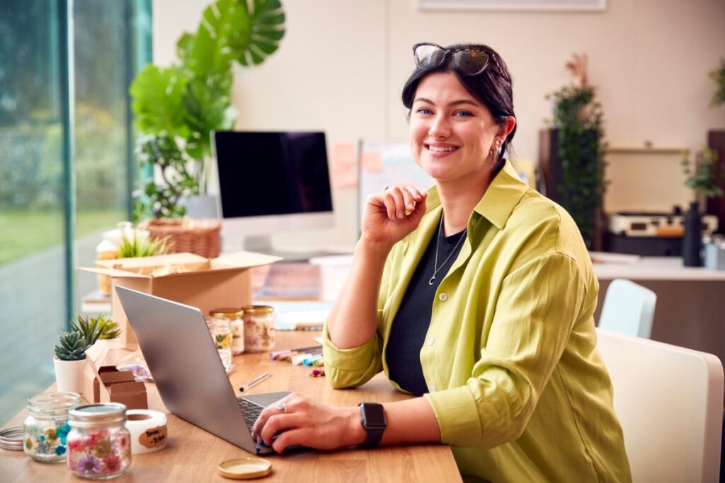 Une femme souriante travaillant avec son ordinateur