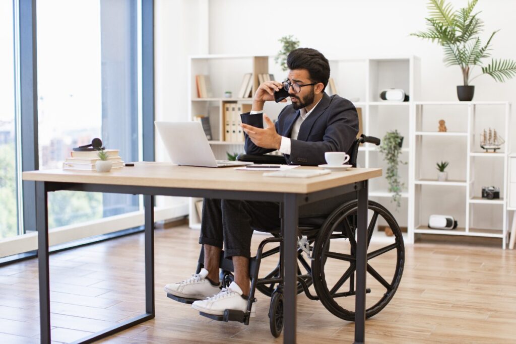 Un homme en fauteuil qui travaille avec son ordinateur