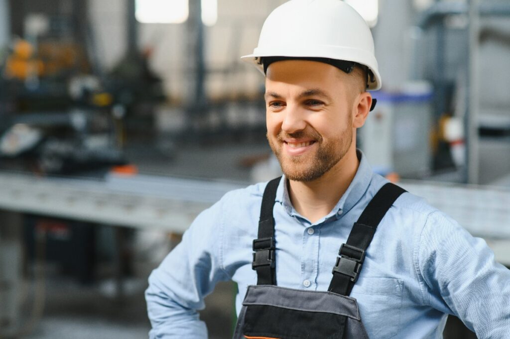 Un ouvrier de bâtiment souriant portant un casque
