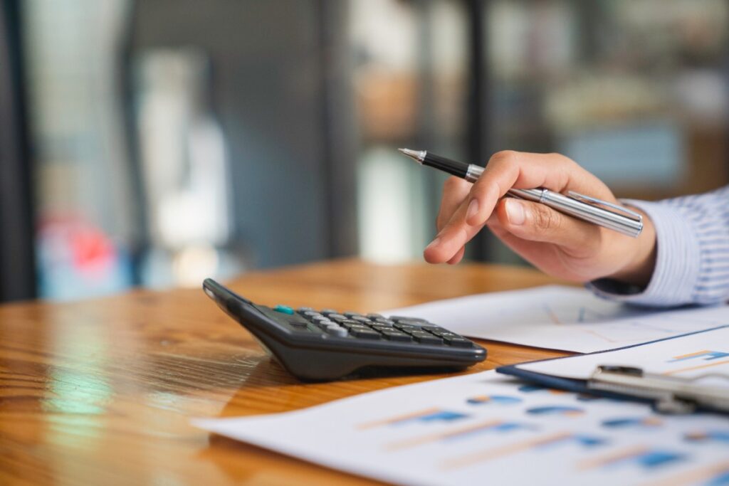 Une personne faisant une analyse financière avec une calculatrice et un stylo