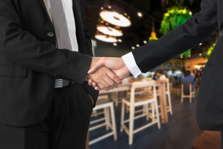 Deux personnes se serrant la main dans un restaurant