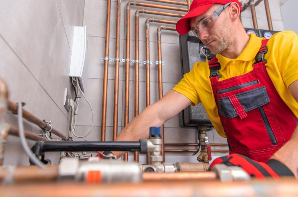 Un plombier travaillant avec un tuyaux en cuivre