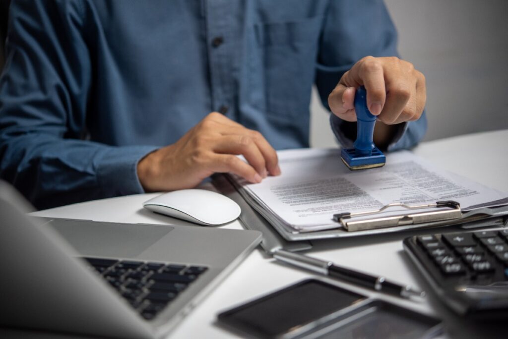 Un homme mettant du tampon sur des documents
