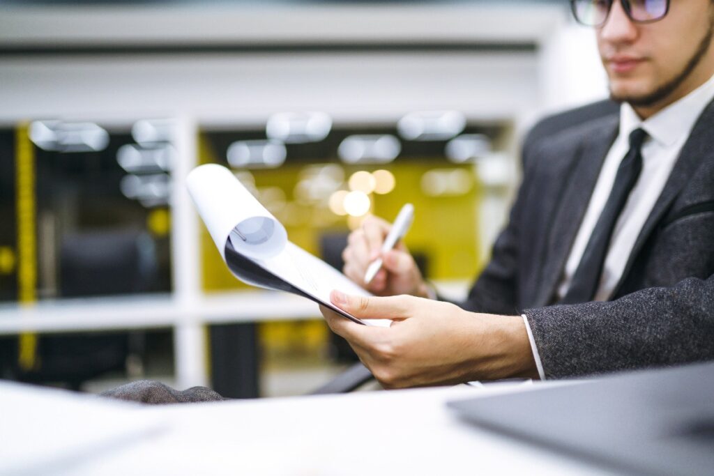 Un homme qui signe des documents dans son bureau