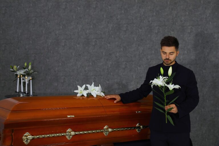 Un homme tenant des fleurs près d'un cercueil