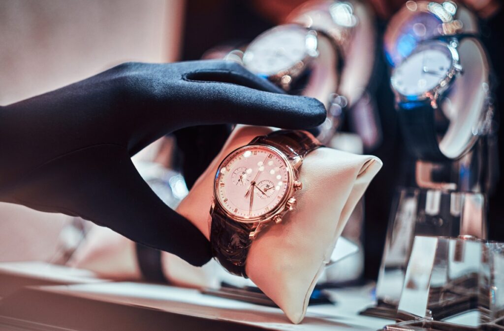 Main avec un gant qui tient une montre