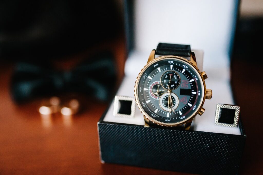 Une montre avec des boutons de manchette dans une boîte
