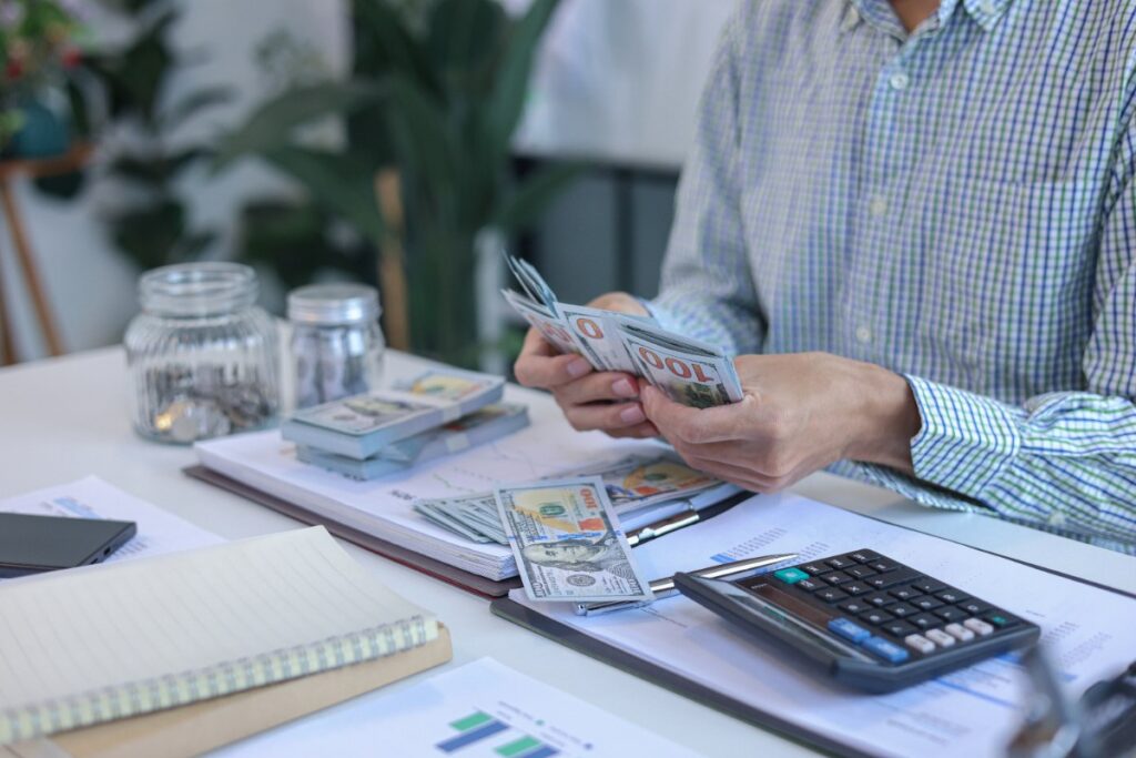 Une personne comptant des piles de monnaies dans son bureau